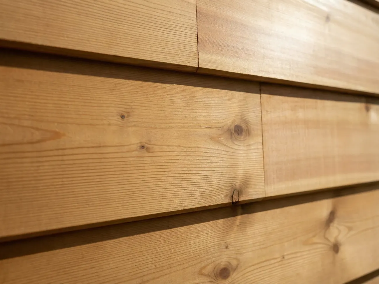 Restored cedar siding detail showing wood grain through fresh stain