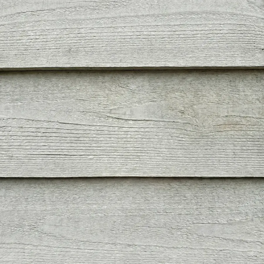 Gray weathered cedar siding showing UV sun damage