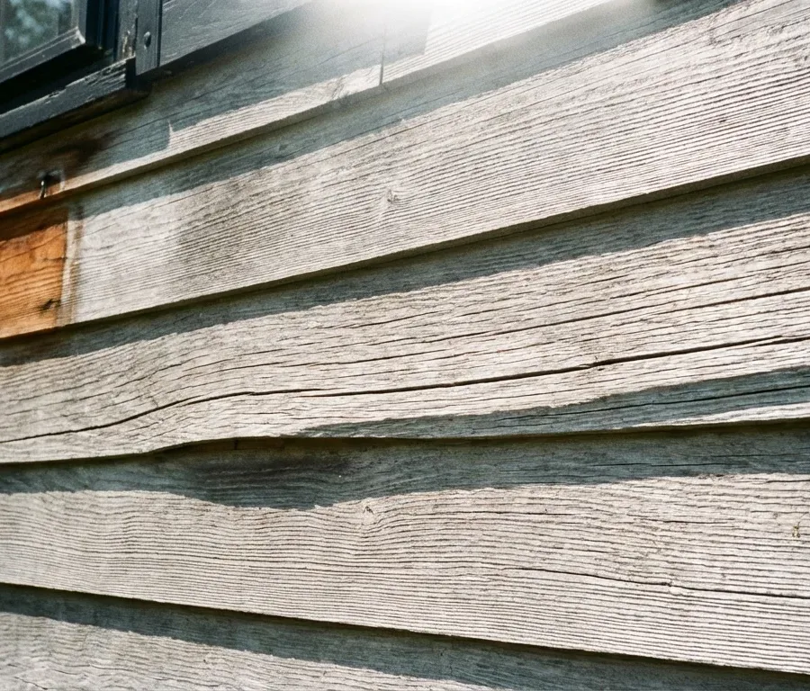 Gray weathered cedar siding showing UV sun damage