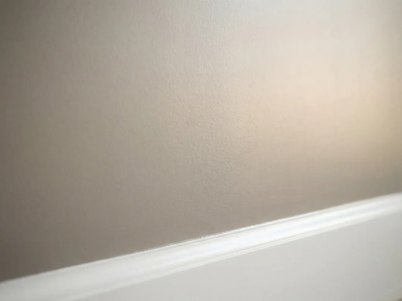 Close-up detail of a smooth interior wall finish showing professional paint application