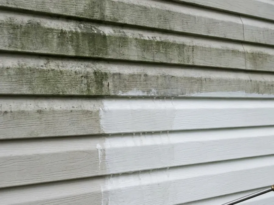 Vinyl siding being soft washed to remove mold and dirt buildup